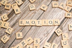 scrabble tiles spelling the word emotion on a wooden surface