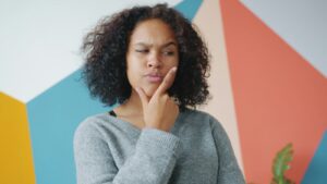 Woman with hand on chin, thinking